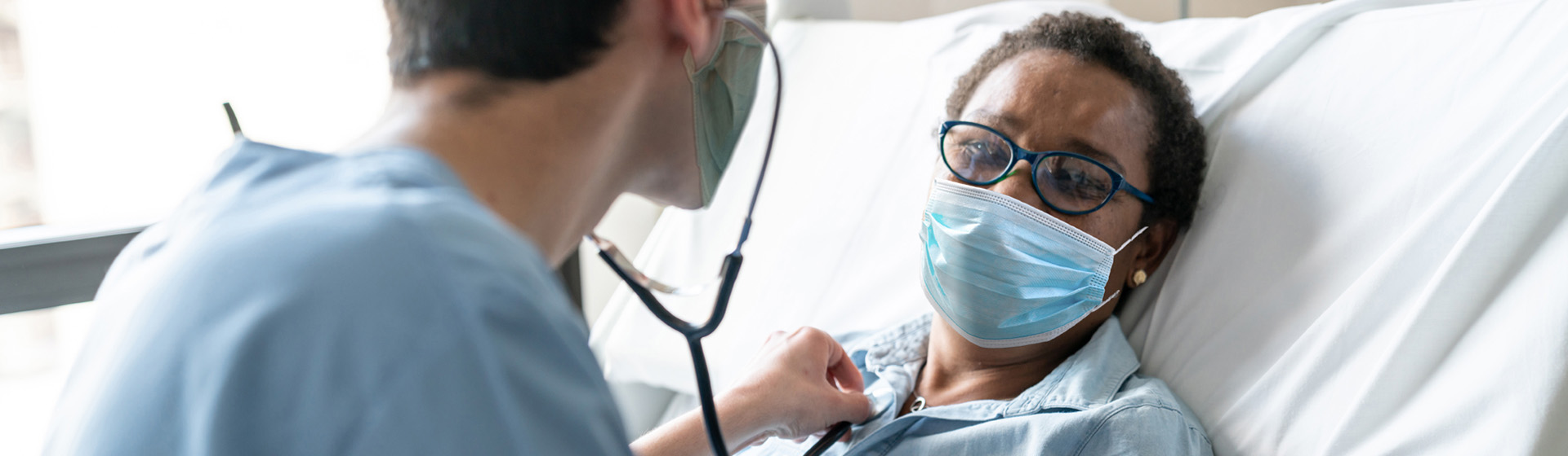 Nurse checking female patient's heart with a stethoscope