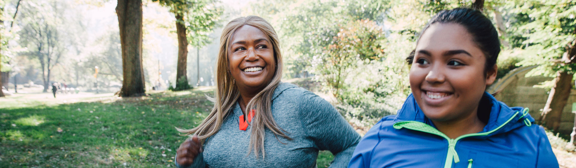 Woman smiles outside as she jogs